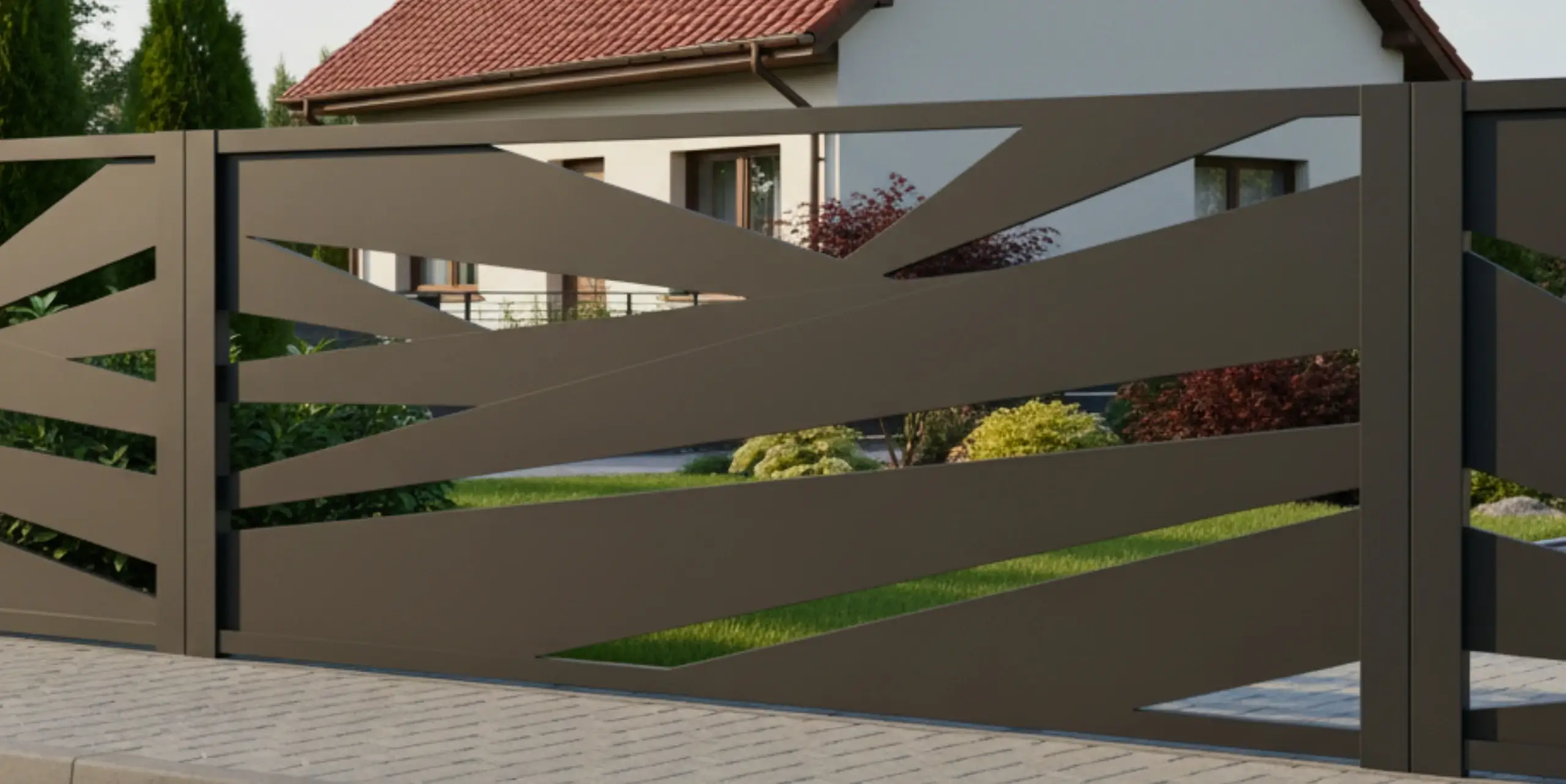 Ogrodzenie frontowe z paneli metalowych ciętych laserowo na tle zieleni ogrodowej.